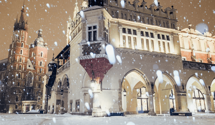 Snow falling in Kraków Old Town at night in winter